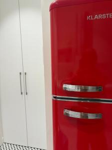 a red refrigerator sitting next to a white cabinet at Apartament Dominic in Sopot