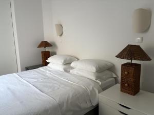 a bedroom with a white bed with two lamps at Apartament Dominic in Sopot +5 photos