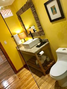 een badkamer met een wastafel en een spiegel bij Turtle Beach Sanctuary, Utila in Utila