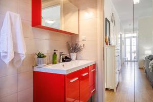 - une cuisine avec des placards rouges et un évier blanc dans l'établissement The Lucky 12, à Corfu 60 autres photos