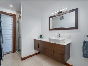 a bathroom with a sink and a mirror at Summer Palms - Tairua Holiday Home in Tairua +30 photos
