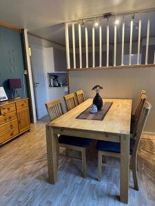 a dining room table with chairs and a vase on it at Solstad in Senja