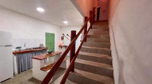 eine Treppe in einem Zimmer mit einer Küche und einem Kühlschrank in der Unterkunft Casa Brisa das Aguas Piscina e Churrasqueira in Tatuamunha