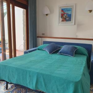 Una cama azul con dos almohadas encima. en Casa Claudia - Positano Center 5 minutes to beach, en Positano 45 fotos más