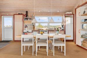 a kitchen with a table and chairs and a refrigerator at TV1694-Bindslev-Musvagevej-8 in Tversted