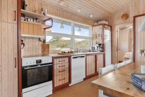 a kitchen with white appliances and a wooden ceiling at TV1694-Bindslev-Musvagevej-8 in Tversted +12 photos