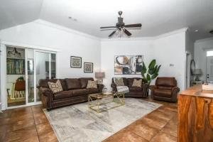 Una sala de estar con sofás y un ventilador de techo. en Cypress Ct Estate, en Siloam Springs