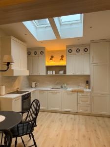 a kitchen with white cabinets and a skylight at Apartamenty Guzik 32 in Krosno +17 photos