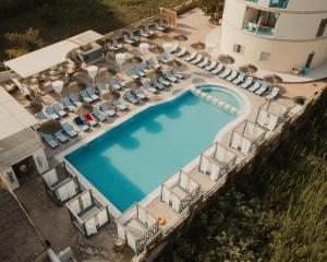 an overhead view of a swimming pool with chairs and a building at Island Kavos Annex studios in Kavos