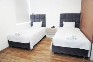 two beds in a small room with wooden floors at Wyka Hotel in Trujillo