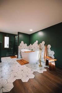 ein Badezimmer mit einer Badewanne und einer grünen Wand in der Unterkunft Emerald Edge Hocking Hills Midcentury Cabin & Hot Tub in South Bloomingville