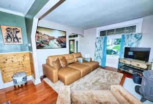 een woonkamer met een bank en een flatscreen-tv bij Nell's Place in Cincinnati