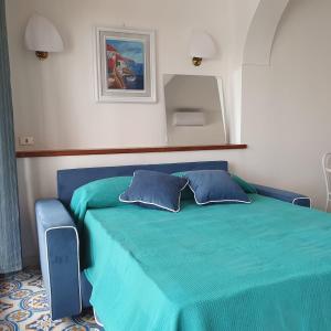 1 dormitorio con 1 cama azul y 2 almohadas en Casa Claudia - Positano Center 5 minutes to beach, en Positano