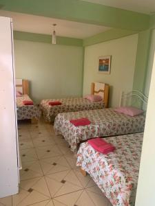 a room with three beds in a room at Hotel Las Colonias in Encarnación