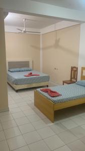 two beds are sitting in a room with at Hotel Las Colonias in Encarnación