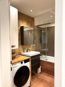 a bathroom with a washing machine and a sink at Wallersee Retreat in Neumarkt am Wallersee