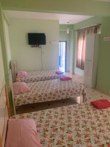 a bedroom with two beds and a flat screen tv at Hotel Las Colonias in Encarnación