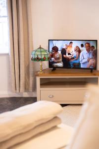 a flat screen tv sitting on a dresser in a bedroom at Charming Apartment with Prime Location in Royal Tunbridge Wells