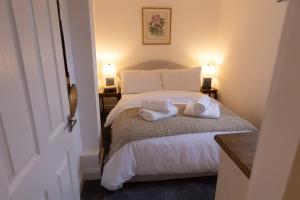 a bedroom with a bed with two towels on it at Charming Apartment with Prime Location in Royal Tunbridge Wells