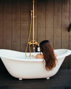 Eine Frau sitzt in einer Badewanne in der Unterkunft Victorian French Cottage - Hot Tub in Hocking Hills in South Bloomingville