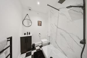 a white bathroom with a shower and a sink at Elevated Escape - Hot tub, sauna, rooftop terrace in Seabrook +44 photos