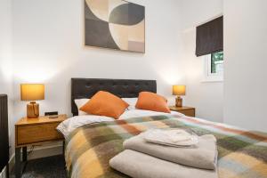a bedroom with a bed with orange pillows and two lamps at Elevated Escape - Hot tub, sauna, rooftop terrace in Seabrook