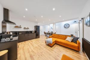 a living room with a couch and a kitchen at Elevated Escape - Hot tub, sauna, rooftop terrace in Seabrook