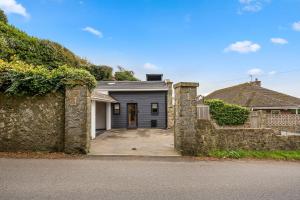 a house with a stone wall and a garage at Elevated Escape - Hot tub, sauna, rooftop terrace in Seabrook