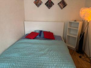 a bedroom with a bed with two red pillows at Bern str 140 in Ostermundigen