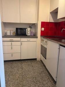 a kitchen with white cabinets and a microwave at Bern str 140 in Ostermundigen