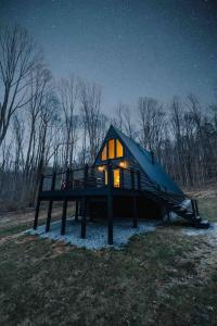 a small cabin in the woods at night at Secluded A-Frame Hocking Hills Hot Tub Fire Pit in South Bloomingville