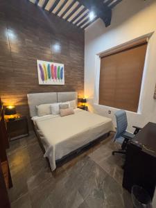 a bedroom with a bed and a desk and a window at Hotel Boutique Casa Zafra in Campeche