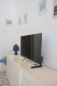 Un televisor sobre una cómoda en una habitación. en Casa Claudia - Positano Center 5 minutes to beach, en Positano