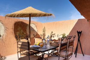a table and chairs with a umbrella on a patio at Lyxig oas i Medina och fantastisk terrass in Marrakech