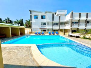a swimming pool in front of a large apartment building at KK Homes in Diani Beach