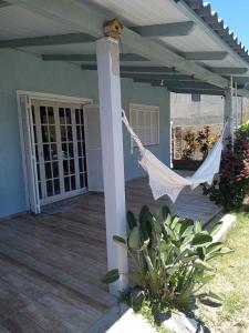 a porch of a house with a hammock on it at summer house 2026 in Tramandaí