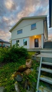 a white house with a staircase in front of it at Charming apartment with two bedroms and beautifull sea view in Fauske in Fauske