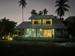 a house with a roof with a bicycle in front of it at pousada Maria da Fé in Vera Cruz de Itaparica