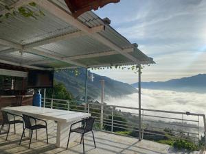 a white table and chairs on a balcony with a view at Finca Panoramica in Barbosa