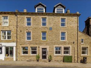 an old brick building with windows on a street at Queen Elizabeth Penthouse Sleeps 6-8 in Stanhope