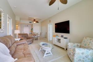 a living room with a couch and a flat screen tv at Waterfront Punta Gorda Condo with Pool Access! in Burnt Store Marina