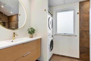 a bathroom with a sink and a washing machine at TV1697-Jerup-Engsig-Baekvej-42 in Bratten Strand