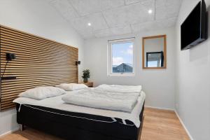 a bedroom with a large bed and a flat screen tv at TV1697-Jerup-Engsig-Baekvej-42 in Bratten Strand