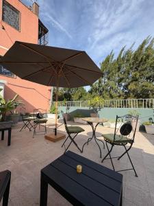a patio with chairs and a table with an umbrella at Casa tua suites in Catania