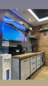 a kitchen with a counter with a tv on the wall at Банний Двір in Kryvyi Rih