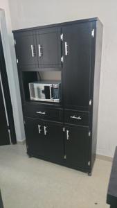 ein großer schwarzer Schrank mit einer Mikrowelle darin in der Unterkunft Allende Cozy Suite - Entrada privada y patio in Buenavista