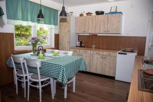 a kitchen with a table with a green and white table cloth at House Zeleni brig in Brestova Draga