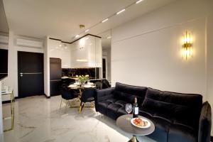 uma sala de estar com um sofá preto e uma mesa em Apartament Glamour Olszynki Park em Rzeszów