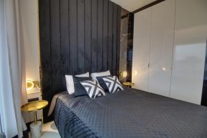 um quarto com uma cama e uma parede preta em Apartament Glamour Olszynki Park em Rzeszów