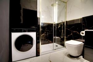 uma casa de banho com uma máquina de lavar roupa e um WC em Apartament Glamour Olszynki Park em Rzeszów mais 11 fotografias